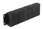 Resembling the Vestil Laminated Dock Bumper 10 X 36 X 4.5 In, a stack of rectangular black textured plates with visible layers along the edges is held by metal brackets on one side. The surface is rough, and the brackets have two holes for mounting.