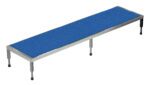 The Vestil Adj Ss Stand 10.5-16.5 H 24W X 96L is a long, rectangular table with a blue textured surface and silver metal legs, featuring adjustable feet with black bases for stability on various surfaces.