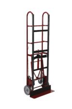 The Vestil Vending -Appliance Cart Ratchet 66 In is a robust two-wheeled red and black cart with a metal frame and flat loading platform. Designed for heavy items, it features curved handles for easy grip and maneuvering, with wheels at the base for stability.