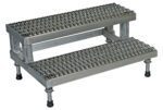 The Vestil Adj Ss Step Mate Stand 2 Step 35.75 x 22.87 In is a metal platform with a textured surface for grip, adjustable feet for stability, and an industrial design suitable for heavy-duty use.