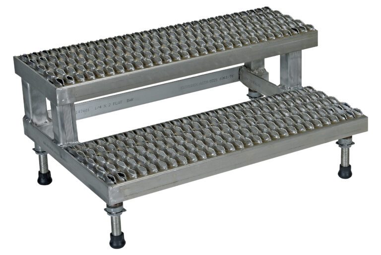 The Vestil Adj Ss Step Mate Stand 2 Step 35.75 x 22.87 In is a metal platform with a textured surface for grip, adjustable feet for stability, and an industrial design suitable for heavy-duty use.