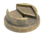 A round, weathered metal object resembling a cap or lid has a wedge-shaped cutout on top, visible scratches, and a dull, brownish patina like an aged Vestil Bronze Drum Bung Socket 3/8 In Drive.