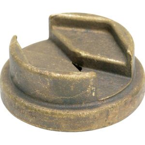 A round, weathered metal object resembling a cap or lid has a wedge-shaped cutout on top, visible scratches, and a dull, brownish patina like an aged Vestil Bronze Drum Bung Socket 3/8 In Drive.