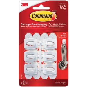 The Command™ Hooks and Strips - Mini 17006 by 3M package shows six hooks and eight strips, supporting up to 0.5 lb (225 g) for damage-free hanging, featuring a graphic of measuring spoons in use.