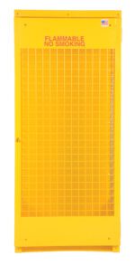 The Vestil Vertical Cylinder Cabinet-5-10 is a tall, bright yellow unit with a mesh front and FLAMMABLE NO SMOKING in red at the top. An American flag sticker in the upper right corner enhances its appearance, making it perfect for storing flammable materials securely.