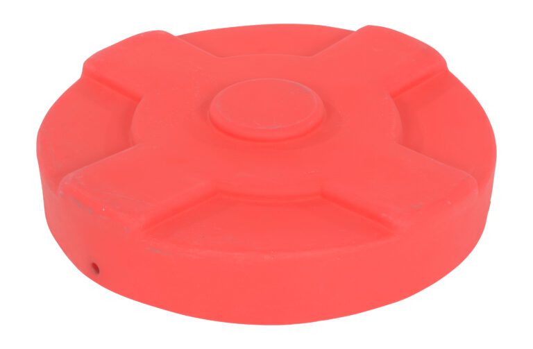 A round, red plastic disc resembling the Vestil Red Drum Cover 30 Gallon, with a slightly raised center and four evenly spaced rectangular protrusions around the edge. The surface is smooth and unmarked.