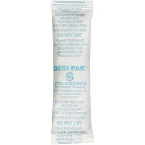 The 1 x 3 1/2 x 1/4 Tyvek® Clay Desiccants come in a white packet labeled DESI PAK with blue text and warnings like DO NOT EAT. These desiccants are crucial for moisture absorption in packaging and are available in a 5-gallon pail containing 700 per case.
