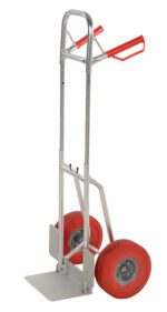 The Vestil Fold-Down Aluminum Hand Truck-Red Ureth features a silver construction with red urethane handles and tires. Its sturdy metal frame and flat loading platform make it ideal for transporting heavy items efficiently.