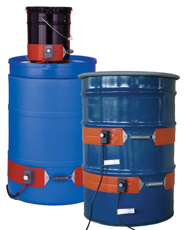 Two large blue industrial barrels have orange Vestil Steel Drum Heaters designed for 55-gallon drums at 120 V, with one visible black cable. An extra barrel lid heater sits on top of the rear barrel.