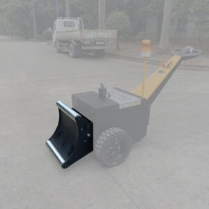 A small industrial machine with a yellow handle and metal scoop rolls across the pavement. Beside it, a truck stands amid greenery. This site likely uses a Vestil Roll Pusher, 20 Width, buzzing with efficiency and precision.