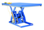 The blue Vestil Electric Hydraulic Lift Table 3K 48X72 features a rectangular top supported by scissor-lift mechanisms, a yellow coiled control cable, and visible mechanical components beneath.