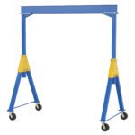 The Vestil Fixed Ht. Stl Gantry Crane 6K 10Ft Kd is blue and yellow, equipped with four swivel casters. It features a strong steel frame with two A-frame legs linked by a horizontal beam, ideal for effortlessly lifting heavy loads.