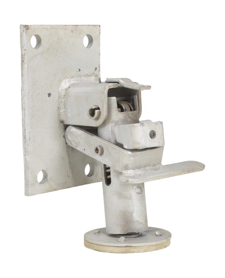 A metallic hinge with a square plate with four mounting holes is attached to a cylindrical base, similar to the Vestil Floor Lock 7 to 8-3/16 In Height. The hardware displays wear and age, featuring a slightly rustic finish.