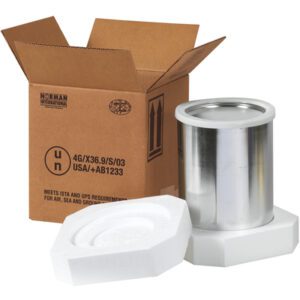 The MH-USA 8 1/2 x 8 1/2 x 9 5/16 Haz Mat Shipper Kit is open, with shipping codes visible on the cardboard, revealing a shiny metal canister and two white foam inserts for securely transporting the 1-gallon container.