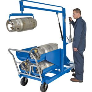 A person in safety gear operates the blue Vestil LP Tank Truck, which holds multiple kegs with its 6-tank capacity. The hydraulic arm elevates one keg while sturdy wheels ensure easy mobility.