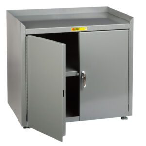 A gray metal cabinet, similar to the Little Giant Stationary Shop Cabinets w/Leg Levelers, has one door partially open, showing an inner shelf. It features a flat top and adjustable feet for elevation. A small label with text decorates the front.