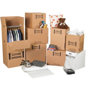 The MH-USA Small Home Moving Kit includes various cardboard moving boxes, with some labeled fragile. A special clothing wardrobe box holds hanging shirts, while a pillow, teddy bear, books, pans, and a baking tray are nestled among packing materials and paper.