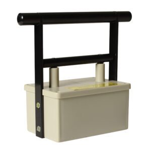 A beige rectangular electric fence tester with a robust black handle offers the efficiency of a Vestil Magnetic Catcher. It features two cylindrical connectors and a yellow label on top, making its simple design ideal for practical outdoor use.