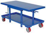 The Vestil Low Profile Mech Post Table 24 X 48 has a blue hydraulic lift, flat surface, sturdy base on four wheels, and a side manual crank handle for effortless height adjustment, providing versatility for various tasks.