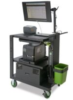 Mobile workstation cart with a mounted monitor displaying software, a small printer on top, a larger printer on the middle shelf, and a green handheld device on the side. It has wheels and a trash bin attached to the side.