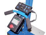 Close-up of industrial equipment with electronic panels and padded handles. The Vestil Quick Lift Option-Ht Index 21 Setpoints features digital displays, a large red emergency stop button, integrated cables on a blue metal frame, offering 21 setpoints for precise control.
