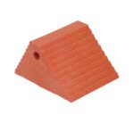 A red, triangular doorstop with horizontal ridges evokes the grip of a Vestil Plastic Dual Slope Wheel Chock Orange. It has a small side hole for easy handling or hanging, and its rubbery surface enhances stability.