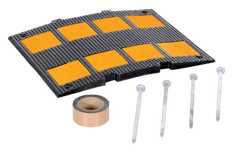 The Vestil Middle Section Asphalt Kit 23.5 includes a black rubber mat with eight orange sections, a beige tape roll, and five silver nails. Its versatile design features a curved edge with perforated holes and measures 23.5 inches for enhanced functionality.