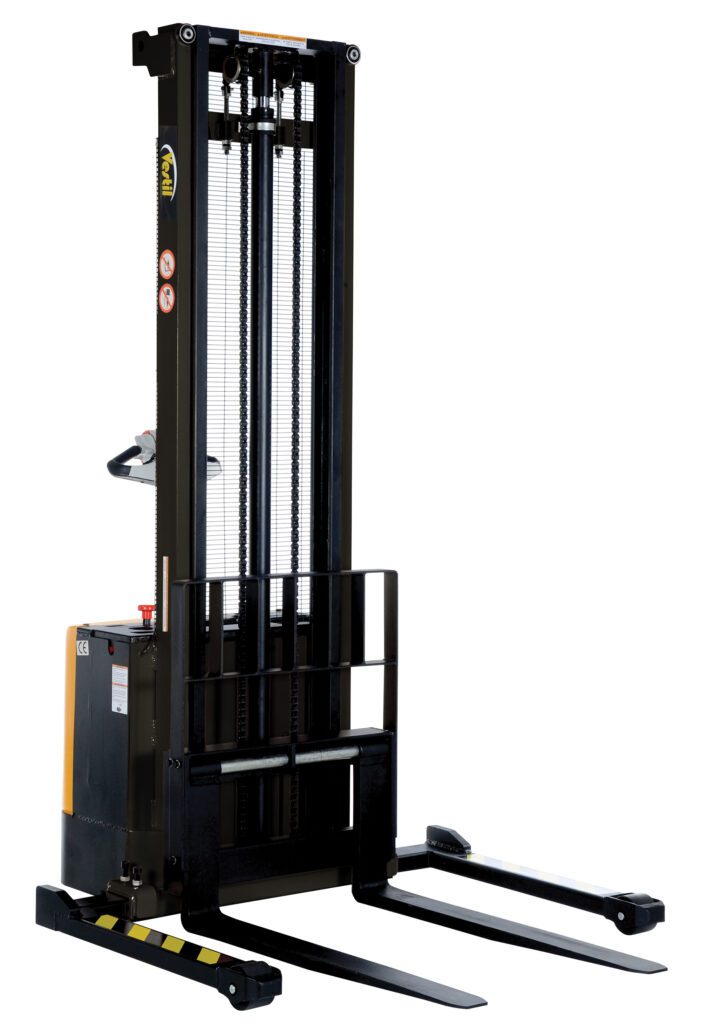 The Vestil Adjust Powered Lift Stacker 150In Raised is an electric pallet stacker with a 150-inch mast, two base forks, a control handle, and safety labels. Primarily black with yellow accents, its ideal for lifting and transporting pallets in warehouses.