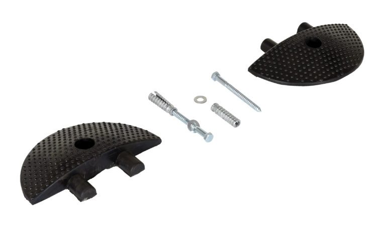 Two textured black rubber doorstops with holes and protrusions, resembling Vestil Speed Bump Heavy Duty Concrete End Caps, are spaced apart. Between them are metal screws, an expansion plug, a washer, and an anchor bolt, all neatly arranged on a white background.