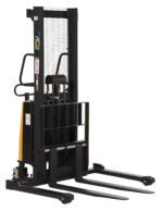 The black Vestil Adjustable Stacker W/Powered Lift 63 In, with long metal forks and a protective guard, includes a handle and wheels for efficient pallet lifting and movement.