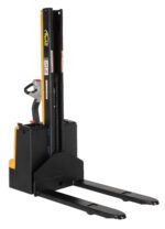 The image shows a yellow and black Vestil Stacker Pwr Lift/Dr Fix Frk 62In 1500 Lb electric pallet stacker with long metal forks for efficient lifting and transporting of pallets, featuring a rear-positioned control handle.