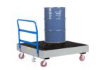 A blue metal barrel sits on a Little Giant 4-Drum Spill Control Cart with a gray wheeled platform. It features a floor lock system, red caster wheels, a blue handle, and a grated surface with a small yellow label for spill control.