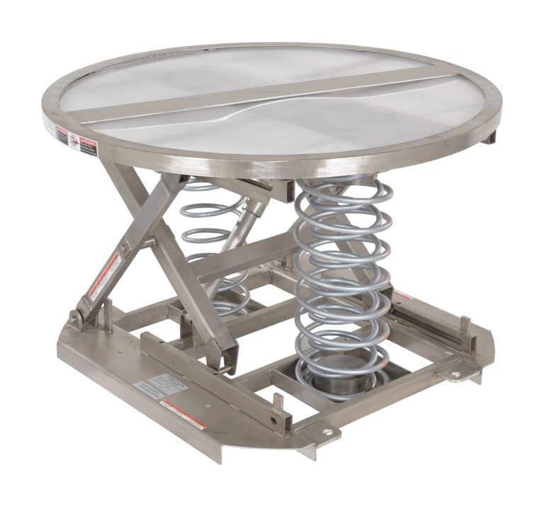 The Vestil Spring Scissor Table Partial Ss 4,500 is a stainless steel pallet lift table with a round top and large visible coil springs beneath it, making height adjustment effortless for loading and unloading tasks.