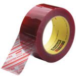 The 2 x 110 yds. Clear (6 Pack) 3M Security Message Box Sealing Tape 3779 unrolls, revealing CHECK SEAL BEFORE ACCEPTING in white and red. Featuring a glossy finish and yellow core with the Scotch logo, it ensures secure packaging with every seal.