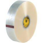 A large roll of 2 x 1000 yds. Clear 3M™ 371 Carton Sealing Tape, featuring a red and black patterned core, stands upright against a white backdrop. This shiny tape is perfect for packaging needs and comes in a case of six.