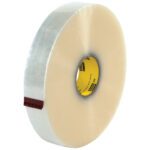 The 2 x 1000 yds. Clear 3M™ 373 Carton Sealing Tape, available in a convenient 6/Case pack, has a shiny surface, with a yellow core labeled in black and a small red tab showing its adhesive side.