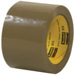 A roll of glossy tan Scotch® Box Sealing Tape 373, featuring its adhesive surface and labeled with Scotch 373 next to the brands logo, is part of a 3 x 110 yds (6 Pack) and sits upright with a smooth finish on a flat surface.