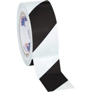 Partially unrolled, a roll from the 2 x 36 yds. Black/White (3 Pack) Tape Logic® Striped Vinyl Safety Tape displays bold diagonal stripes with the label visible inside.