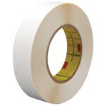 A roll from the 3/4 x 36 yds. (2 Pack) of 3M™ 9579 Double Sided Film Tape lies on a white background, featuring a brown cardboard core with printed text and the iconic manufacturer logo. Perfect for all your sticking needs.