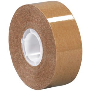 A roll of Tape Logic Heavy-Duty Adhesive Transfer Tape with a white core, shiny surface, and strong brown adhesive side lies on its side. The MH-USA 3/4 x 18 yds. - 2 per case reflects light slightly.