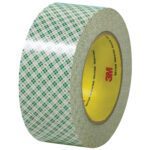 A roll of 3M™ - 410M Double Sided Masking Tape (2 x 36 yds., 3 Pack) stands upright with a green plaid pattern and a yellow core featuring the red 3M logo, ideal for precision tasks needing reliability.