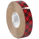 The 1/2 x 36 yds. 3M™ 976 Adhesive Transfer Tape, partially unspooled and wrapped around a white cylindrical core, features a red and black plaid pattern with thin yellow lines.