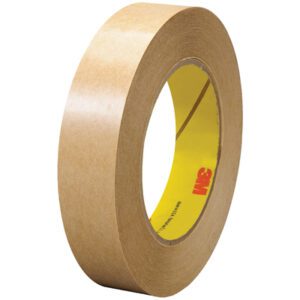 A 1 x 60 yds. roll of 3M™ 465 Adhesive Transfer Tape stands upright, displaying its beige texture and thickness. The inner core is yellow with multiple red 3M logos printed on it.