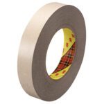 A roll of gray 1 x 60 yds. 3M™ 9471 Adhesive Transfer Tape, featuring a yellow and red plaid inner core, is upright and slightly tilted, highlighting its thickness and smooth adhesive texture.