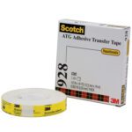 A roll of 3M™ 928 Repositionable Adhesive Transfer Tape, 1/2 x 36 yds., is in the foreground with its red and black tartan box behind it. The tape says Repositionable, and the box details product size and thickness.