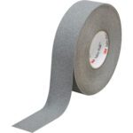 The 2 x 60 Gray 3M™ Safety-Walk™ Tape - 370 (2 Rolls/Case), featuring a gritty, anti-slip surface, is shown partially unrolled and upright on a white background to improve safety and traction.
