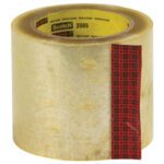 A roll of 3M Label Protection Tape 3565, featuring a red plaid strip, measures 4 x 110 yds, labeled Scotch 3565, and is set against a white backdrop.