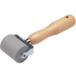 The 3M™ Safety-Walk™ Hand Roller - 903 includes a small gray rubber wheel, a wooden handle with a hanging hole, and a metal bracket for secure attachment, ensuring simplicity and functionality.