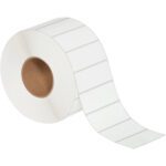 The MH-USA 4 x 1 1/2 White Thermal Transfer Labels (3850/Roll) come as white rectangles on a continuous strip, partially unrolled with a brown cardboard core.