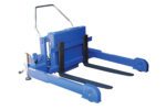 The Vestil Tilt Master Strad DC Power 6000 lb Cap is a compact manual pallet lifter with a silver handle and two black forks, featuring DC power. Its sturdy design is shown on a white backdrop, making it ideal for lifting pallets.